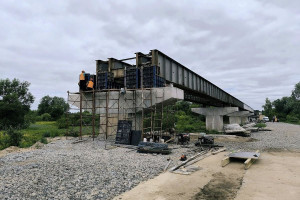 Пошкоджений на початку вторгнення: на Київщині ремонтують міст через річку Тетерів (ФОТО)